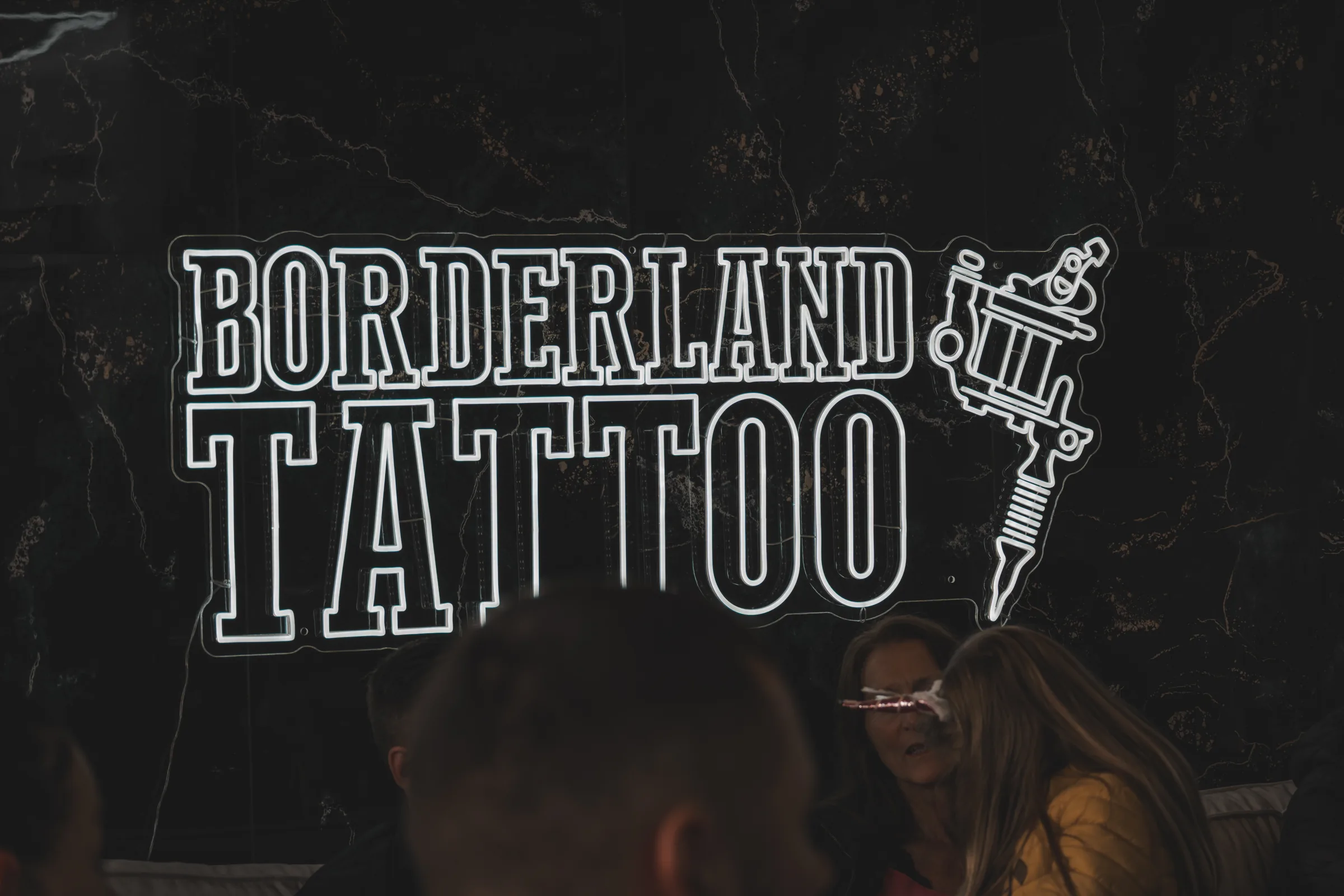 Neon-Schild über der Sitzgruppe im Studio — Neueröffnung Borderland Tattoo Aachen, Event-Reportage, Foto eoglou media design Aachen