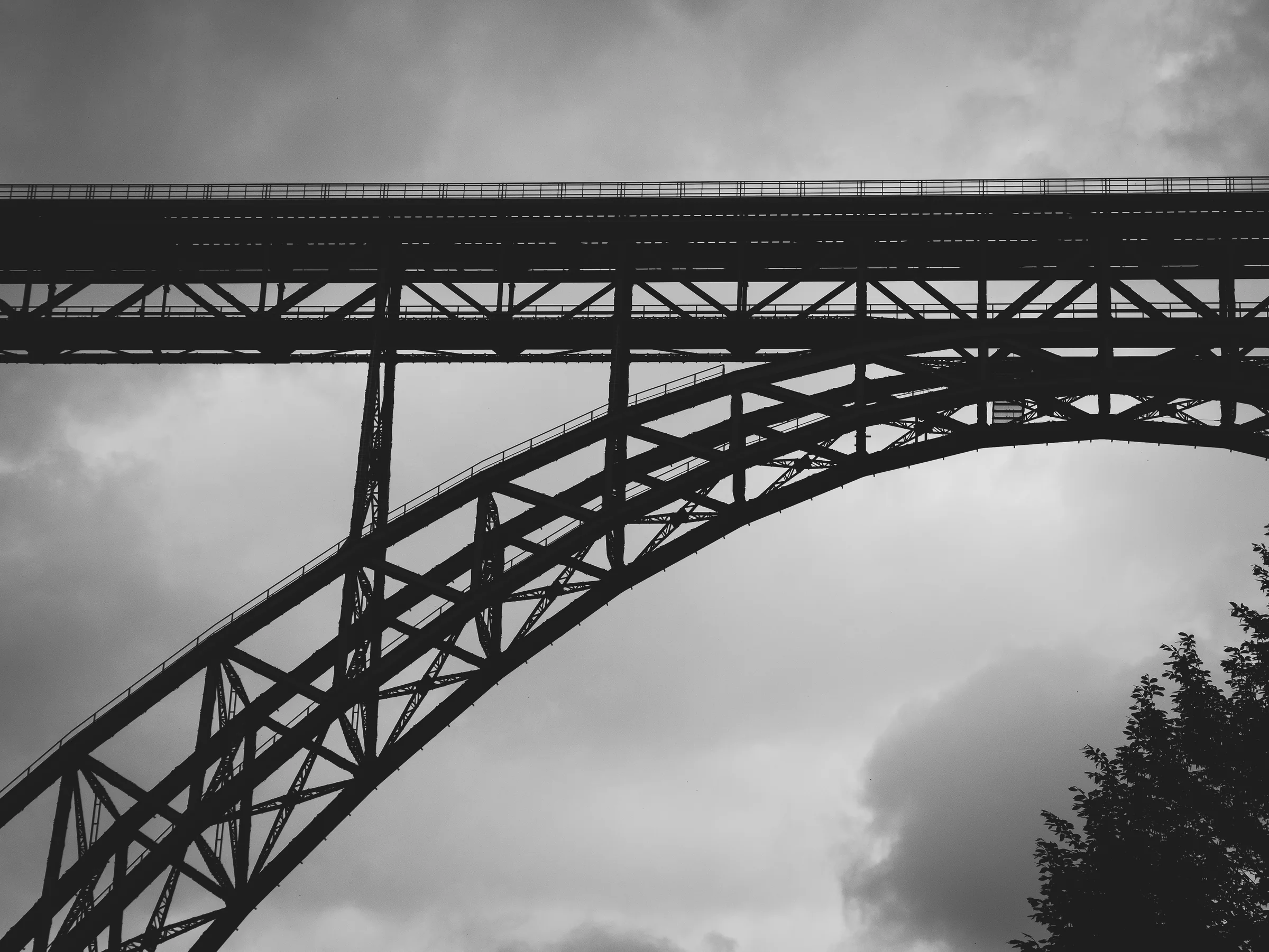 Bogen aus dem Tal — Hügelsilhouette, Schwarzweiß-Architekturfotografie von Emrach aus Aachen