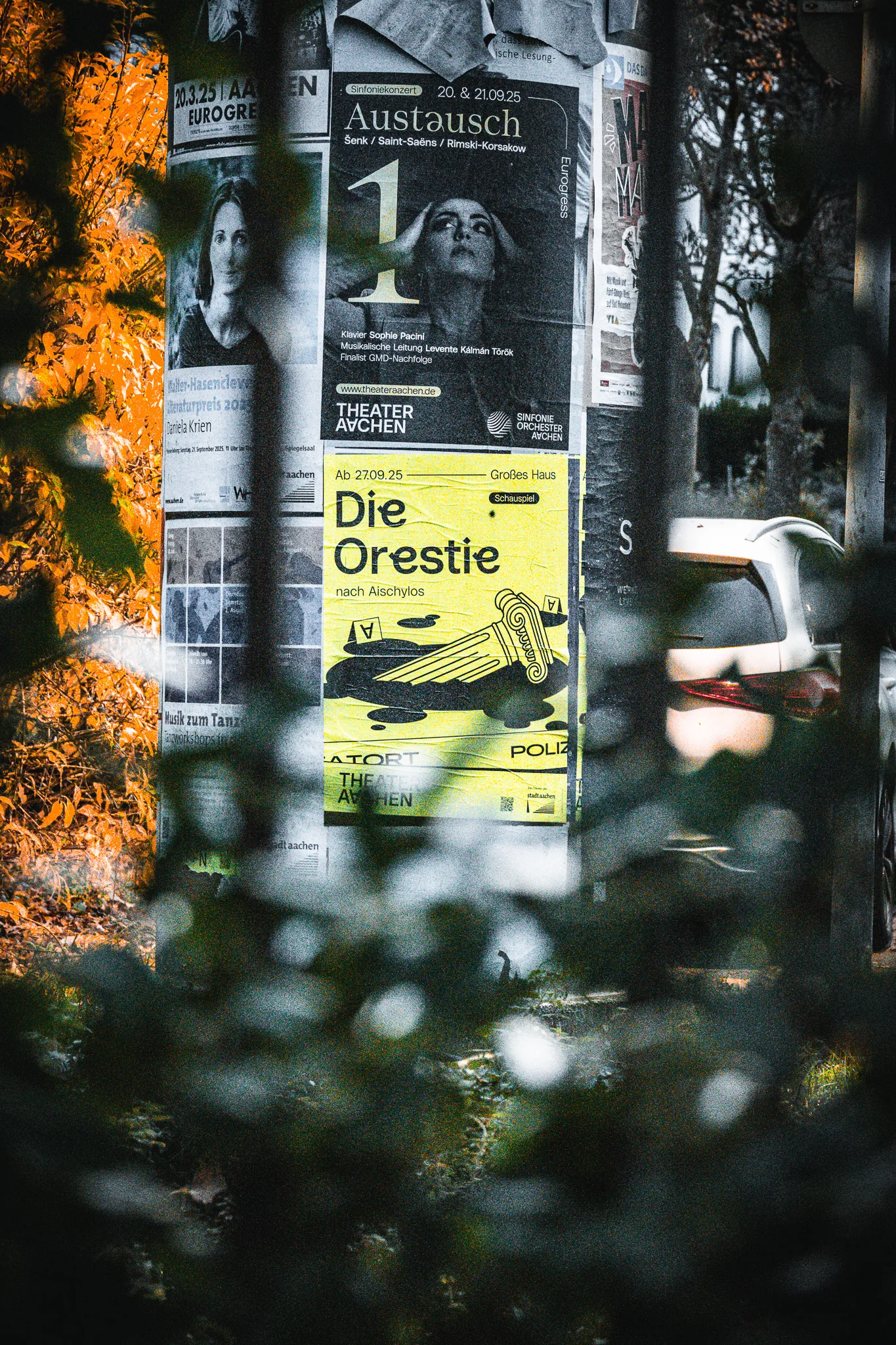 Street-Photography Aachen — Theaterplakat Detail mit Herbstlaub, dokumentarisch mit Nikon Z50 II, Herbst 2025, von Emrach aus Aachen